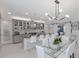 Open-concept kitchen boasts a large island with seating, modern lighting, and seamless access to the living area at 5557 Long Shore Loop, Sarasota, FL 34238