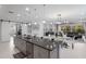 Bright open kitchen and living space featuring a large island with seating and modern furnishings at 5557 Long Shore Loop, Sarasota, FL 34238