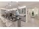 Modern kitchen with gray cabinetry, sleek stainless steel appliances, a large center island, and white marble floors at 5557 Long Shore Loop, Sarasota, FL 34238