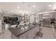 Open-concept kitchen with stainless steel appliances, gray cabinetry, large island, and open view into the living room at 5557 Long Shore Loop, Sarasota, FL 34238