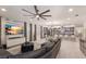 Spacious open concept living room with modern decor, gray sectional sofa, and view into the kitchen and dining area at 5557 Long Shore Loop, Sarasota, FL 34238