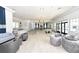 Spacious lounge area with comfortable seating, elegant lighting, and kitchen at Mattamy Homes at Tradition at 5557 Long Shore Loop, Sarasota, FL 34238