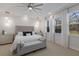 Bright main bedroom with a ceiling fan, pendant lights, and large windows at 5557 Long Shore Loop, Sarasota, FL 34238
