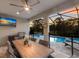The outdoor living space features a covered patio, outdoor kitchen, TV, and pool at 5557 Long Shore Loop, Sarasota, FL 34238