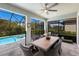 Screened-in patio features a dining table with seating, with a view of the sparkling pool and lush backyard at 5557 Long Shore Loop, Sarasota, FL 34238