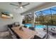 The screened-in patio boasts an outdoor kitchen, a dining table with seating, and a view of the sparkling pool at 5557 Long Shore Loop, Sarasota, FL 34238