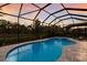 Relaxing private pool and spa with a screened enclosure and lush greenery at 5557 Long Shore Loop, Sarasota, FL 34238