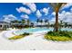Enjoy the pool with plenty of lounge chairs surrounded by lush green landscaping, palm trees, and blue skies at 5557 Long Shore Loop, Sarasota, FL 34238