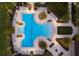 Stunning aerial view of the resort-style swimming pool at Mattamy Homes at Tradition surrounded by palm trees and lounge chairs at 5557 Long Shore Loop, Sarasota, FL 34238