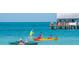 Water view of ocean activities, including kayaking, paddle boarding, and socializing on a pier at 5557 Long Shore Loop, Sarasota, FL 34238