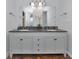 Bathroom vanity featuring double sinks, dark countertops, and white cabinetry at 5860 Brown Ln, Sarasota, FL 34232