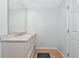 Well lit bathroom with marble countertop vanity and light wood flooring at 5860 Brown Ln, Sarasota, FL 34232