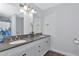 Bathroom featuring double sinks, dark countertops, white cabinetry and shower at 5860 Brown Ln, Sarasota, FL 34232
