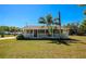 Charming single-story home featuring a cozy front porch, mature trees, and a well-maintained lawn at 5860 Brown Ln, Sarasota, FL 34232