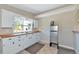 Well-lit kitchen featuring white cabinets, a stainless steel refrigerator, and a window providing natural light at 5860 Brown Ln, Sarasota, FL 34232
