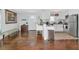 Bright kitchen featuring white cabinets, stainless steel appliances, and hardwood flooring throughout the home at 5860 Brown Ln, Sarasota, FL 34232