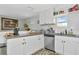 Well-lit kitchen with white cabinetry, stainless steel appliances, and granite countertops at 5860 Brown Ln, Sarasota, FL 34232