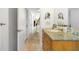 Bathroom with double mirrors, vessel sink, marble countertop, wood cabinets, and hallway view at 587 47Th St, Sarasota, FL 34234