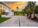 Long driveway leads to a modern home, complete with a basketball hoop and lush landscaping at 587 47Th St, Sarasota, FL 34234