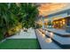 Home exterior featuring a deck with lighting, a fire pit, outdoor seating, and lush landscaping at 587 47Th St, Sarasota, FL 34234