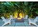 Cozy fire pit with chairs nestled within lush tropical landscaping, perfect for relaxing evenings at 587 47Th St, Sarasota, FL 34234