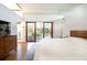 Bright primary bedroom featuring wood floors, TV, and sliding glass doors leading to a balcony at 587 47Th St, Sarasota, FL 34234