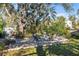 Wide angle landscaped backyard with a fire pit, stone trim, mature oak, and lush tropical landscaping at 603 Frances St, Nokomis, FL 34275