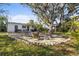 Wide angle landscaped backyard features outdoor seating, a fire pit, lush trees, well-manicured lawns at 603 Frances St, Nokomis, FL 34275