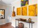 Hallway featuring terracotta floors, a console table with art, and a guitar hanging on the wall at 603 Frances St, Nokomis, FL 34275