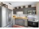 Well-equipped kitchen featuring stainless steel appliances, gray cabinetry, and a neutral backsplash at 603 Frances St, Nokomis, FL 34275