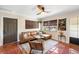 Inviting living room with a leather sectional sofa, terracotta tile flooring, and natural light from a large window at 603 Frances St, Nokomis, FL 34275