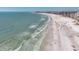 Gorgeous aerial view of sandy beach, ocean waves, and shoreline buildings on a clear sunny day at 6285 Midnight Pass Rd # 201, Sarasota, FL 34242