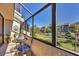 Relaxing screened-in balcony with cozy seating and a scenic view of the community grounds at 6285 Midnight Pass Rd # 201, Sarasota, FL 34242