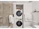 Clean bathroom featuring a stacked washer/dryer, glass-enclosed shower, and modern fixtures at 6285 Midnight Pass Rd # 201, Sarasota, FL 34242