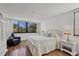 Bright bedroom featuring wood flooring, a large window with nature views and white furnishings at 6285 Midnight Pass Rd # 201, Sarasota, FL 34242