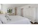 Airy bedroom with neutral decor, featuring white furniture and bedding and a window letting in natural light at 6285 Midnight Pass Rd # 201, Sarasota, FL 34242