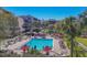 Community pool with red umbrellas, lounge chairs and beautiful palms at 6285 Midnight Pass Rd # 201, Sarasota, FL 34242