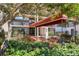 Inviting condo entrance with covered walkway, lush garden, and attractive landscaping at 6285 Midnight Pass Rd # 201, Sarasota, FL 34242