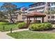 Condo complex featuring a gazebo, well manicured lawn, palm trees, and covered parking at 6285 Midnight Pass Rd # 201, Sarasota, FL 34242
