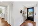 Inviting condo hallway with wood floors, closet and stylish decorations leading to the front door at 6285 Midnight Pass Rd # 201, Sarasota, FL 34242