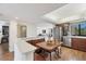 Bright kitchen with stainless appliances, wood cabinetry, and breakfast table overlooking a cozy living area at 6285 Midnight Pass Rd # 201, Sarasota, FL 34242