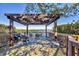 Inviting outdoor deck featuring a pergola, cozy seating, and scenic water views at 6285 Midnight Pass Rd # 201, Sarasota, FL 34242