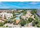 Stunning aerial view of waterfront condos with community pools and lush landscaping under a beautiful sky at 6342 Midnight Pass Rd # 212, Sarasota, FL 34242