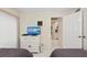 Comfortable bedroom with a TV, tiled floors, and a view to the entry hall at 6342 Midnight Pass Rd # 212, Sarasota, FL 34242