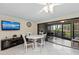 Bright dining area featuring a modern table set, television, and access to the screened in patio at 6342 Midnight Pass Rd # 212, Sarasota, FL 34242