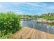 Picturesque view of dock on calm waters with lush greenery and clear skies at 6342 Midnight Pass Rd # 212, Sarasota, FL 34242