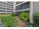 Low angle of Condo building with mature landscaping and tropical foliage at the base at 6342 Midnight Pass Rd # 212, Sarasota, FL 34242