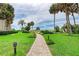 Beautifully manicured greenway leading to the beach with palm trees and blue skies at 6342 Midnight Pass Rd # 212, Sarasota, FL 34242
