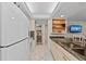 Bright kitchen with granite counters and white appliances, offers an opening into an adjacent bathroom at 6342 Midnight Pass Rd # 212, Sarasota, FL 34242
