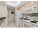 Efficient kitchen featuring white appliances, ample cabinet space, and in-unit laundry at 6342 Midnight Pass Rd # 212, Sarasota, FL 34242